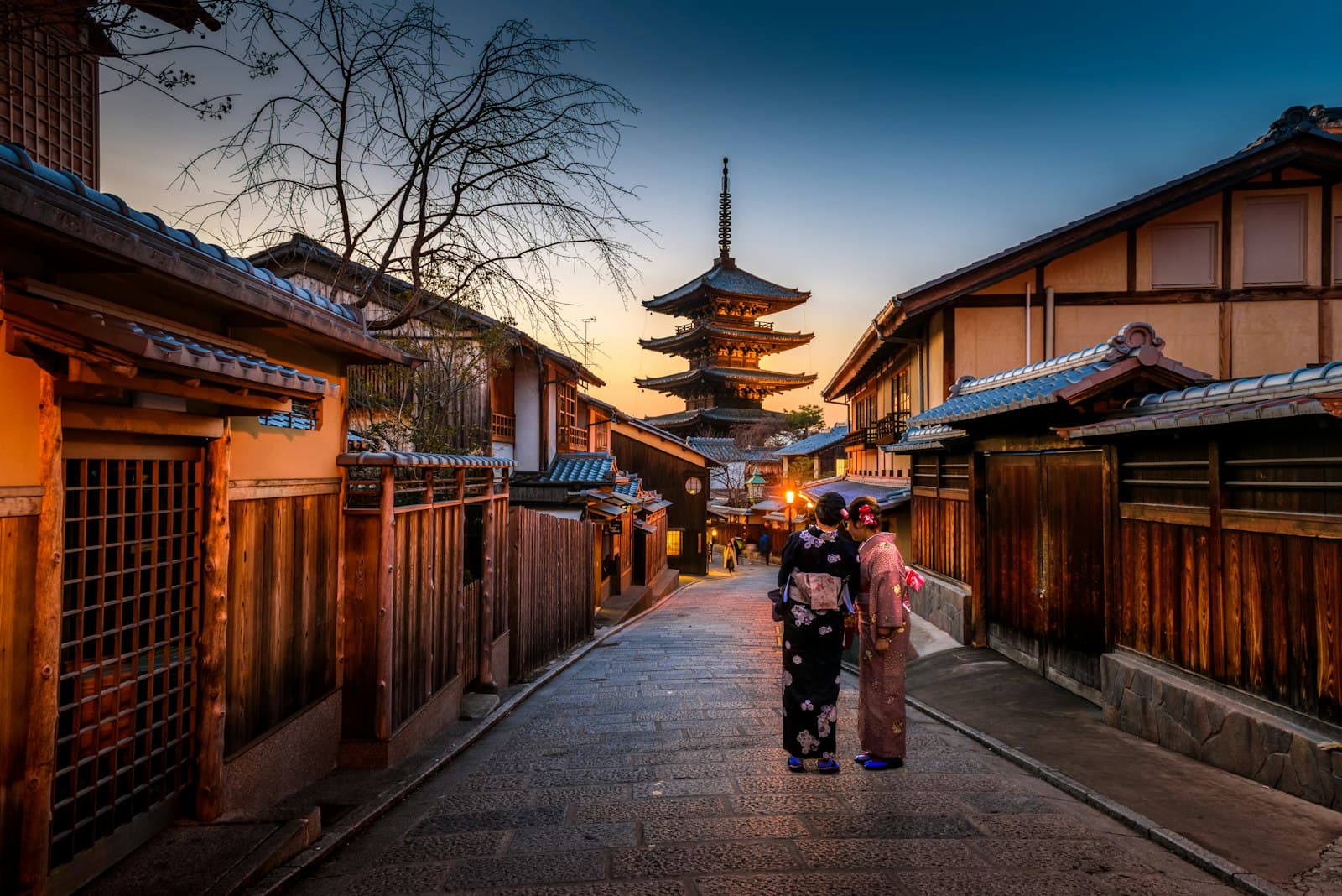 Calle tradicional de Kioto con casas japonesas de madera y la pagoda Yasaka al atardecer