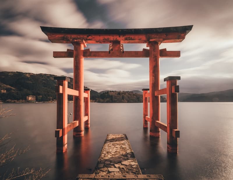 Torii rojo de Hakone sobre el lago Ashi con montañas al fondo