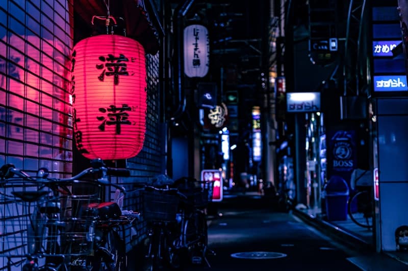 Callejón nocturno en Japón con farolillos rojos iluminados