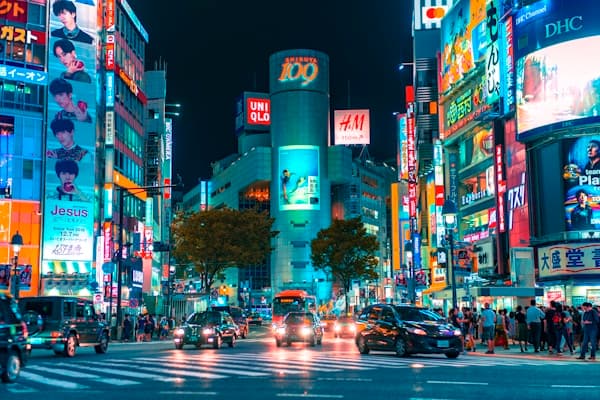 Cruce de Shibuya en Tokio de noche con el edificio Shibuya 109 y letreros luminosos